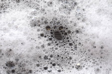 Foto de Espuma de lavado blanca sobre fondo gris oscuro, vista superior - Imagen libre de derechos