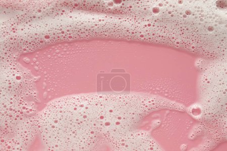 Téléchargez les photos : Mousse de lavage blanche sur fond rose pâle, vue de dessus - en image libre de droit