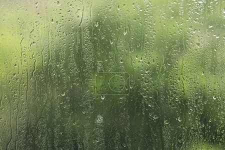 Ventana de vidrio con gotas de lluvia como fondo, primer plano