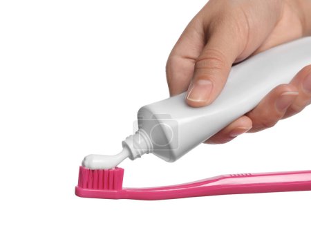 Foto de Mujer aplicando pasta de dientes sobre cepillo sobre fondo blanco, primer plano - Imagen libre de derechos