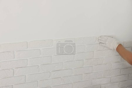 Photo for Worker installing decorative wall tiles in room, closeup - Royalty Free Image