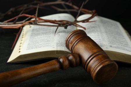 Judge gavel, bible and crown of thorns on black table, closeup
