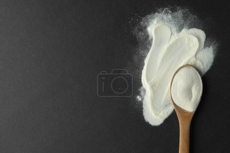 Photo for Spoon of agar-agar powder on black background, flat lay. Space for text - Royalty Free Image