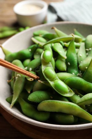 Green edamame beans in pods served on wooden table, closeup