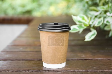 Photo for Paper cup on wooden bench outdoors. Takeaway drink - Royalty Free Image