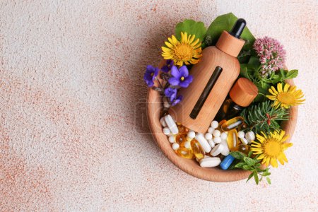 Photo for Bowl with fresh green herbs, extracts, flowers and pills on color table, top view. Space for text - Royalty Free Image