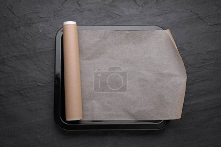 Téléchargez les photos : Plaque de cuisson avec papier sulfurisé sur fond d'ardoise noire, vue de dessus - en image libre de droit