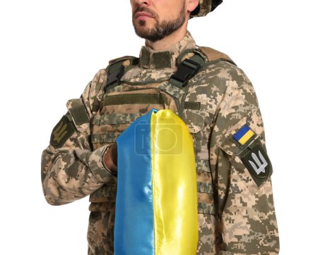 Soldat en uniforme militaire avec drapeau ukrainien sur fond blanc, gros plan