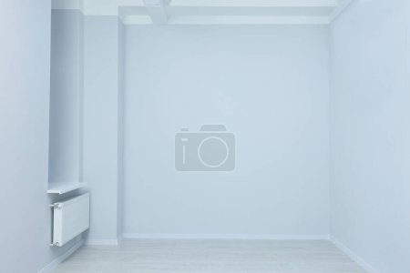 Foto de Habitación vacía con paredes blancas, calentador y tomas de corriente durante la reparación - Imagen libre de derechos