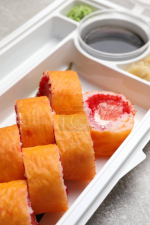 Foto de Deliciosos rollos de sushi mamenori en recipiente de plástico en la mesa, primer plano. Entrega de alimentos - Imagen libre de derechos