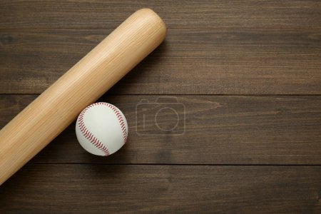 Bate de béisbol y pelota sobre mesa de madera, vista superior con espacio para texto. Equipamiento deportivo