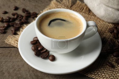 Téléchargez les photos : Tasse de café aromatique et haricots sur table en bois - en image libre de droit