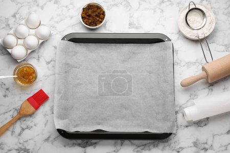 Téléchargez les photos : Plat à pâtisserie avec papier sulfurisé et ingrédients sur table en marbre blanc, plat - en image libre de droit