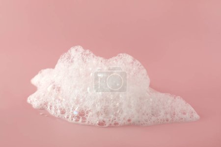 Foto de Espuma de baño esponjosa sobre fondo rosa, primer plano. Producto de cuidado - Imagen libre de derechos