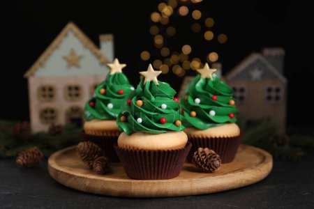 Téléchargez les photos : Cupcakes en forme d'arbre de Noël sur table noire - en image libre de droit