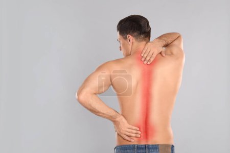 Foto de Hombre que sufre de dolor en la espalda sobre fondo gris claro - Imagen libre de derechos