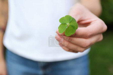 Photo for Woman holding beautiful green four leaf clover outdoors, closeup. Space for text - Royalty Free Image