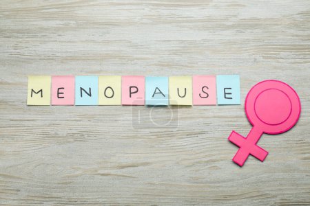 Photo for Colorful paper notes with word Menopause and female gender sign on wooden table, flat lay - Royalty Free Image