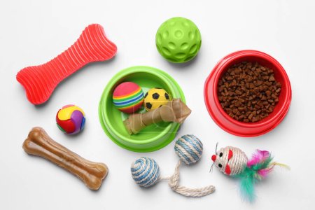 Composición plana con juguetes para mascotas y comida sobre fondo blanco