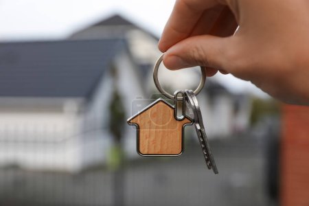 Téléchargez les photos : Femme tenant des clés de maison à l'extérieur, gros plan. Agent immobilier - en image libre de droit