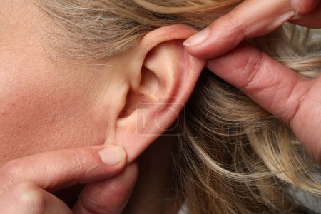 Téléchargez les photos : Vue rapprochée de la femme touchant son oreille - en image libre de droit