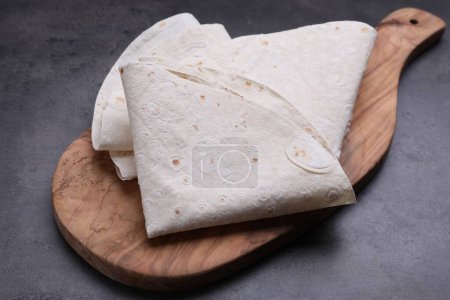 Photo for Delicious folded Armenian lavash on dark table - Royalty Free Image