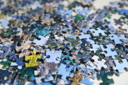 Jigsaw puzzle pieces on table, closeup view