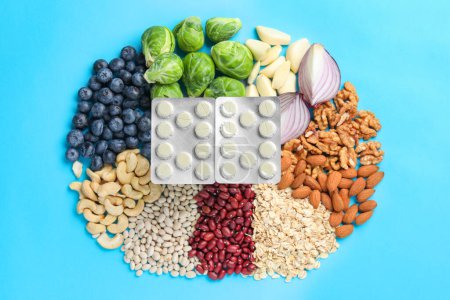 Blisters of pills and foodstuff on light blue background, flat lay. Prebiotic supplements