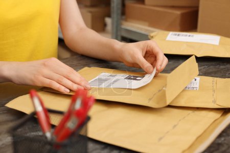 Foto de Trabajador de oficina de correos pegando código de barras en el paquete en el mostrador interior, primer plano - Imagen libre de derechos