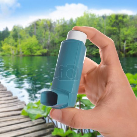 Photo for Man with asthma inhaler near lake, closeup. Emergency first aid during outdoor recreation - Royalty Free Image