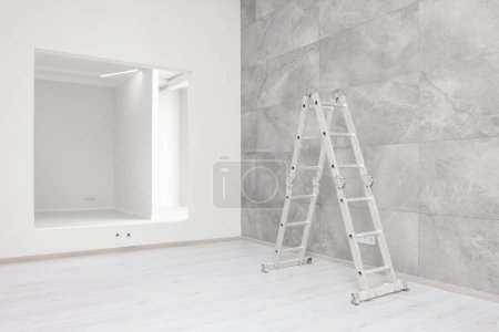 Leerer Raum mit gefliester Wand, Leiter und Öffnung für Scheinfenster während der Reparatur