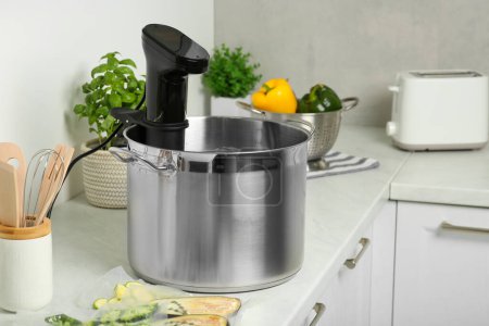 Téléchargez les photos : Pot avec cuisinière sous vide dans la cuisine. Cirateur d'immersion thermique - en image libre de droit
