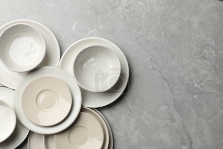 Téléchargez les photos : Ensemble de vaisselle propre sur table grise, plat. Espace pour le texte - en image libre de droit