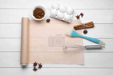 Téléchargez les photos : Cuire du papier sulfurisé et différents ingrédients sur une table en bois blanc, poser à plat. Espace pour le texte - en image libre de droit