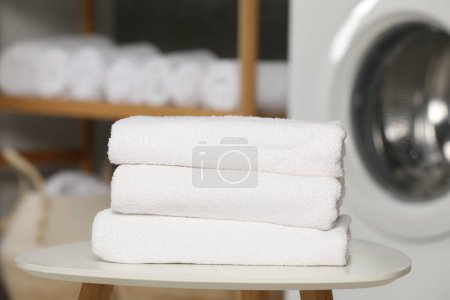 Téléchargez les photos : Serviettes pliées en éponge douce sur table blanche dans la salle de bain, gros plan - en image libre de droit