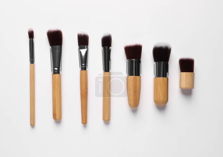 Different makeup brushes on white background, flat lay Poster 626040116