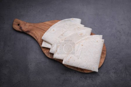 Photo for Delicious folded Armenian lavash on dark table, top view - Royalty Free Image