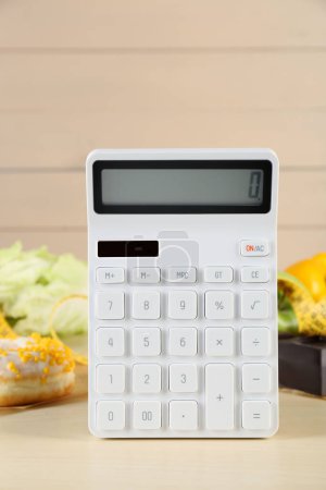 Photo for Calculator and food products on wooden table. Weight loss concept - Royalty Free Image