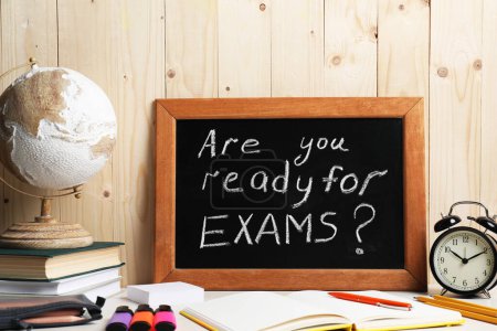 Photo for Blackboard with question Are You Ready For Exams? on white table near wooden wall - Royalty Free Image