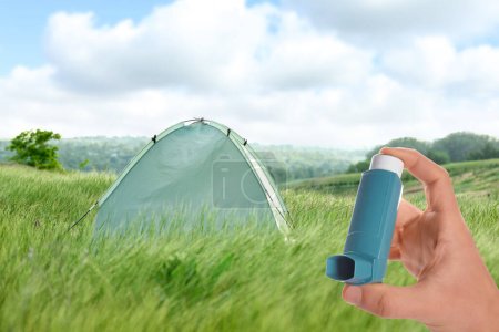 Photo for Man with asthma inhaler in green field, closeup. Emergency first aid during outdoor recreation - Royalty Free Image