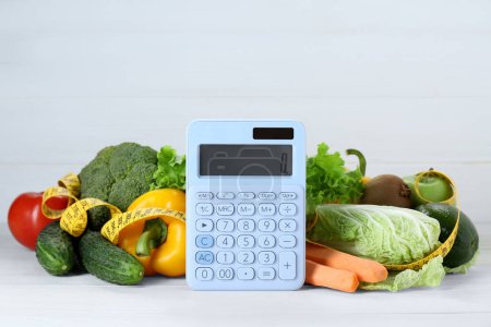 Photo for Calculator and food products on white wooden table. Weight loss concept - Royalty Free Image