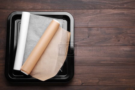 Téléchargez les photos : Rouleaux de papier parchemin dans une plaque de cuisson sur une table en bois, vue sur le dessus. Espace pour le texte - en image libre de droit