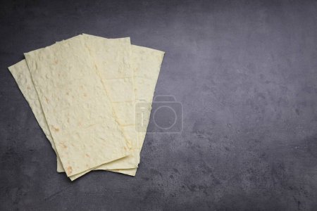 Photo for Delicious Armenian lavash on dark table, top view. Space for text - Royalty Free Image