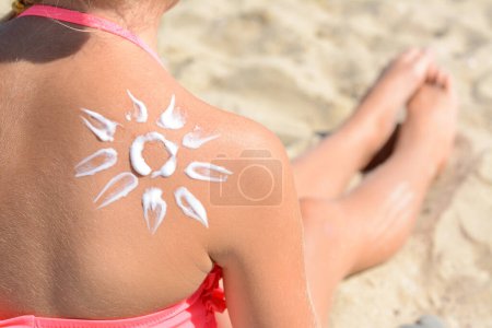 Téléchargez les photos : Petite fille avec crème de protection solaire sur le dos à l'extérieur, gros plan. Espace pour le texte - en image libre de droit