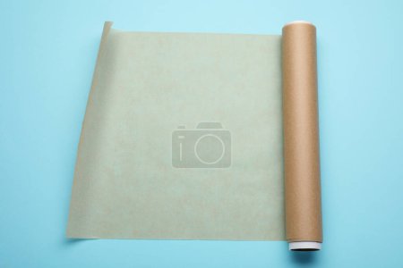 Téléchargez les photos : Rouleau de papier cuisson sur fond bleu clair, vue de dessus - en image libre de droit