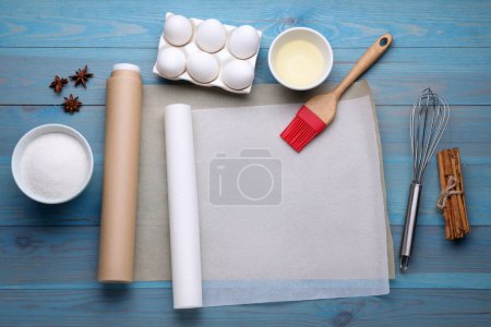 Téléchargez les photos : Rouleaux de papier sulfurisé de cuisson, différents ingrédients et outils de cuisine sur table en bois bleu clair, pose plate. Espace pour le texte - en image libre de droit