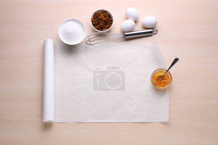 Téléchargez les photos : Cuire du papier sulfurisé et différents ingrédients sur une table en bois, poser à plat. Espace pour le texte - en image libre de droit