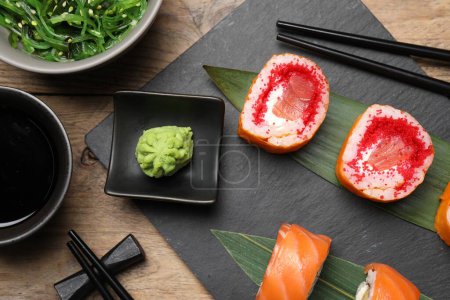 Foto de Composición plana con deliciosos rollos de sushi sobre mesa de madera - Imagen libre de derechos