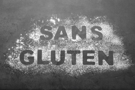 Foto de Palabras Sans gluten escrito con harina sobre fondo gris, vista superior - Imagen libre de derechos