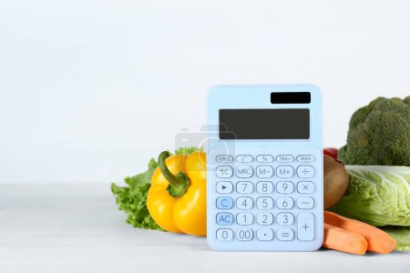 Photo for Calculator and food products on white wooden table, space for text. Weight loss concept - Royalty Free Image